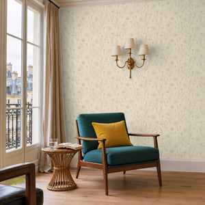 Meadow Cream peel and stick wallpaper in a reading corner with a green armchair and a wall sconce