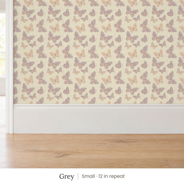 Butterfly Kisses Grey peel and stick wallpaper, small 12 in repeat, above a white baseboard and oak floor