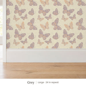 Butterfly Kisses Grey peel and stick wallpaper, large 24 in repeat, above a white baseboard and oak floor