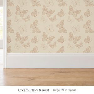 Butterfly Kisses Cream, Navy & Rust peel and stick wallpaper, large 24 in repeat, above a white baseboard and oak floor