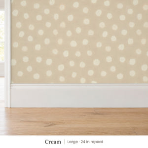 Nellie Cream peel and stick wallpaper, large 24 in repeat, above a white baseboard and oak floor