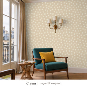 Nellie Cream peel and stick wallpaper, large 24 in repeat, in a reading corner with a green armchair