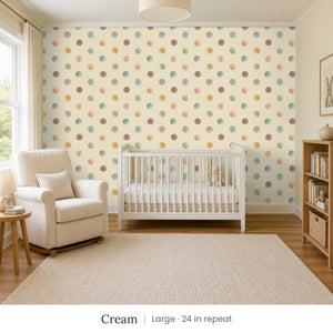 Celia Cream peel and stick wallpaper, large 24 in repeat, in a nursery with a white crib and an armchair