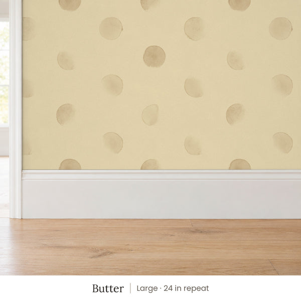 Celia Butter peel and stick wallpaper, large 24 in repeat, above a white baseboard and oak floor