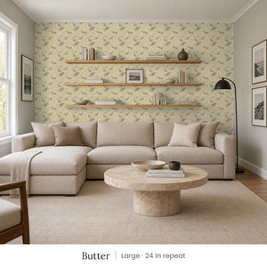 Zelda Butter peel and stick wallpaper, large 24 in repeat, in a family room with a sectional sofa and open shelves