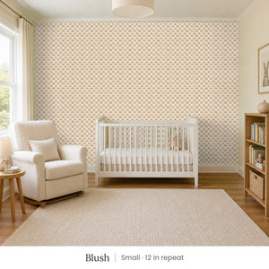 Over the Rainbow Blush peel and stick wallpaper, small 12 in repeat, in a nursery with a white crib and an armchair