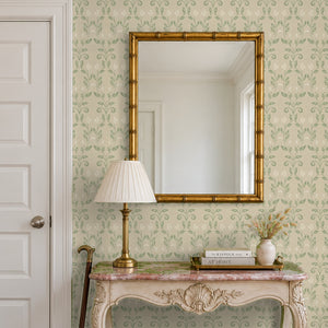 Quince Sage peel and stick wallpaper in an entry with a gold mirror and a carved console