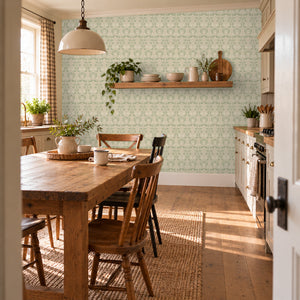 Quince Sage peel and stick wallpaper in a kitchen with a farmhouse table and a pendant light