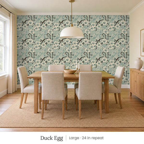 Sakura Duck Egg peel and stick wallpaper, large 24 in repeat, in a dining room with a wood table and upholstered chairs