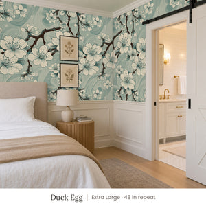 Sakura Duck Egg peel and stick wallpaper, extra large 48 in repeat, in a bedroom with a barn door and botanical prints